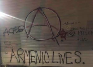 graffiti with anarchy A that says "ARMEANIO LIVES"