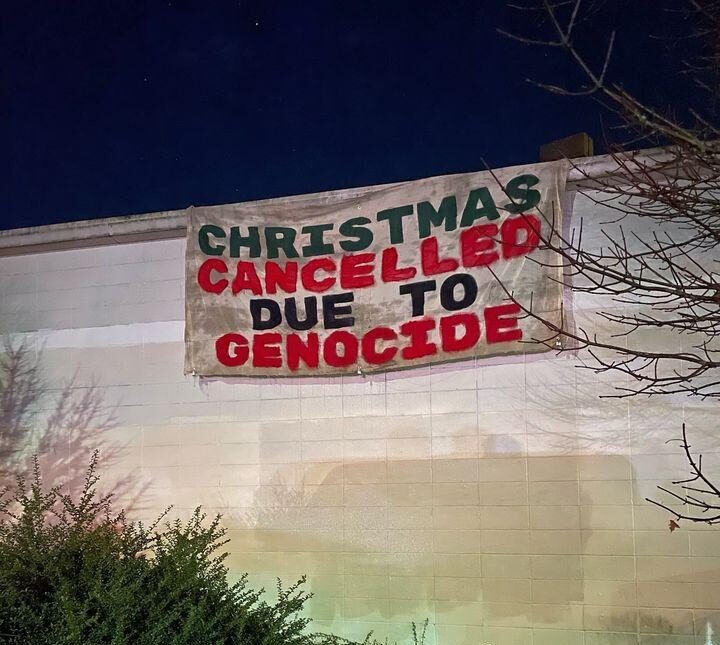 Banner drop reading "Christmas is cancelled due to genocide"